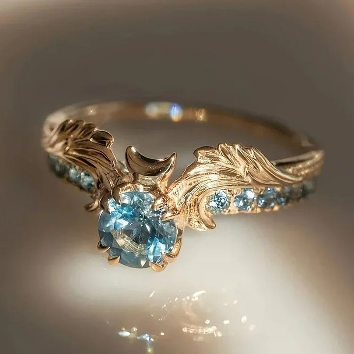 Anel com zircônia azul-marinho e motivo floral