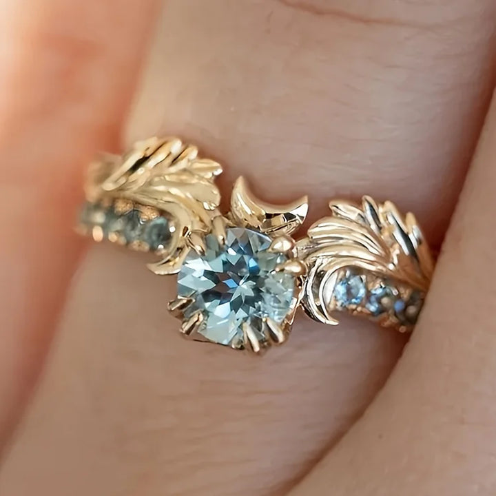 Anel com zircônia azul-marinho e motivo floral